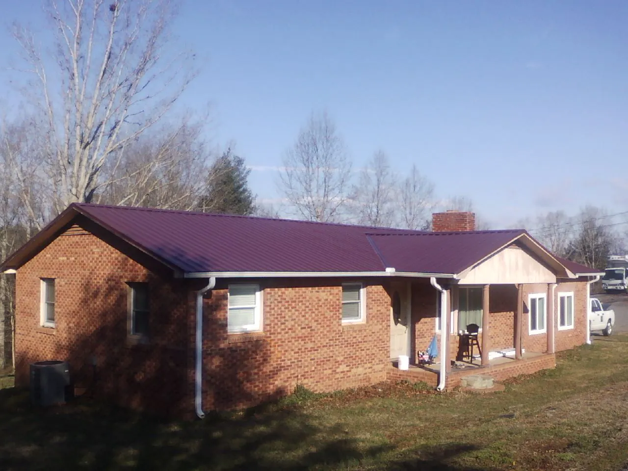 Burgundy metal roof on a brick ranch home with a new addition in Ellensburg