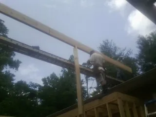 Carpenter setting a ridge beam over a new addition frame — Ice Dam Removal by Roofing Brothers in Ellensburg